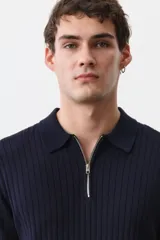Remera polo de manga corta color azul marino en punto acanalado de mezcla de algodón con cuello y medio cierre. Remate acanalado de raya fina en mangas y bajo. Corte ajustado que realza el contorno del cuerpo creando una silueta entallada.