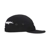 Gorro tipo camp cap color negro con logo de la marca Supreme en etiqueta blanca cosida en el frente. Tiene ojales metálicos en los laterales.