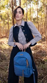 Mochila de tela color salmón con bolsillo frontal con cierre, bolsillos laterales con elástico y bolsillo trasero con cierre. Tiene correas acolchadas y cómodas.