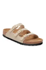 Sandalias tipo chancleta color crema, con tres cintas y hebillas ajustables en la parte superior.