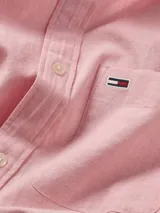 Camisa Tommy Jeans de manga larga, color rosa claro, de corte regular, con cuello abotonado, cierre con botones, bolsillo de parche en el pecho y logo bordado en el bolsillo.