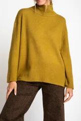 Polera color mostaza de tejido de punto con cuello alto y corte oversize.