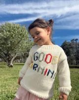 Sweater tejido de lana color crema con bordado de letras de colores formando la frase "Good Morning".