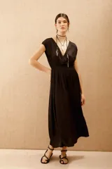 Vestido largo negro con escote en V y mangas cortas caídas.