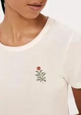 Pijama de short color beige con estampado de flores y hojas. Incluye una remera de manga corta con cuello redondo y un short con cintura elástica.