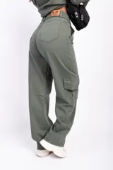 Pantalón cargo color beige, de corte recto y tiro alto, con bolsillos laterales con solapa y bolsillos delanteros.