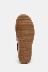 Zapatillas deportivas color borgoña con detalles en blanco y suela color caramelo.