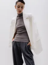 Blazer blanco de corte oversize, con cuello de solapa y cierre con botones.