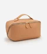 Neceser tipo baúl de material sintético color camel, con asa superior y cierre de cremallera doble.