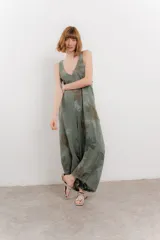 Mono largo verde con estampado floral en tonos marrones, escote en V pronunciado, tirantes anchos y bolsillos laterales.