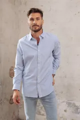 Camisa blanca de corte slim fit, manga larga y cuello clásico. Cierre frontal con botones.
