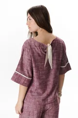 Blusa azul de lino con escote barco y mangas 3/4 con detalle de ribete blanco.