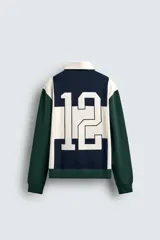 Polo de manga larga con corte relaxed fit, confeccionado en tejido con algodón. Presenta un diseño color block en azul marino, blanco y verde, con cuello solapa con cierre frontal de botonadura. Cuenta con bordados y parches combinados a contraste en delantero y espalda, y acabados en rib.
