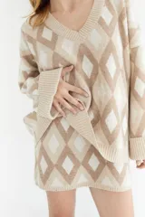 Sweater de lana color beige con diseño geométrico de rombos en tonos beige y blanco, cuello en V y corte holgado.