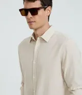 Camisa celeste de lino con cuello camisero, abotonadura frontal y mangas largas.