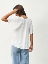 Blusa blanca de mangas cortas con escote redondo y lazos.