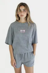 Remera gris de corte cropped con cuello redondo y manga corta. Estampado rectangular en el pecho con texto "Western Avenue Champions".