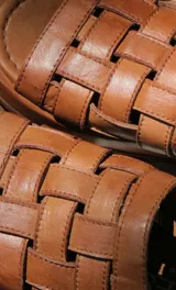 Sandalias bajas color suela, con diseño de tiras anchas entretejidas en el empeine.