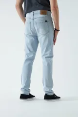 Jean celeste de corte slim, tiro medio y con presillas para cinturón.