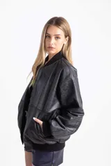 Campera bomber color amarillo pastel de cuero vacuno, con cierre delantero y bolsillos. Tiene puños, cuello y pretina de algodón.