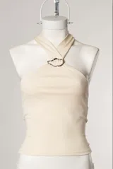 Top blanco de estilo halter con aro metálico en el cuello.