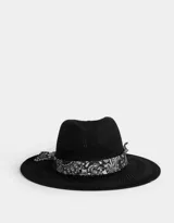 Sombrero negro de paja con ala ancha y cinta estampada de pañuelo en blanco y negro.