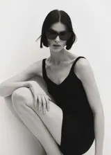 Top negro de punto de canalé con escote de pico y tirantes finos.