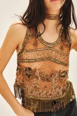 Top corto sin mangas, confeccionado en tul bordado con piedras, lentejuelas, canutillos y flecos de mostacillas.