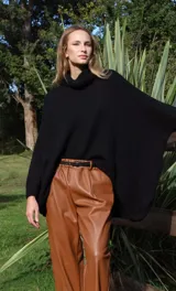 Pantalón babucha verde de cuerina con bolsillos laterales y cinturón fino marrón.