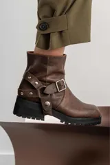 Botas de cuero marrón con hebillas y detalles metálicos, diseño cómodo y moderno.