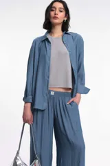 Pantalón de tela color celeste con textura arrugada, corte amplio y cintura elastizada.