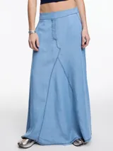 Falda larga de denim liviano color celeste, confeccionada en 100% lyocell. Tiene silueta amplia y fluida, cintura con elástico en la parte trasera, bolsillos laterales y recorte delantero con costuras a contratono.