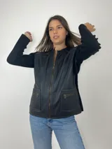 Campera negra con frente de cuero, mangas largas de tejido de lana y cierre frontal con cremallera.