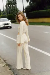 Pantalón palazzo color crudo, de tiro alto con cintura elástica y calado con motivos geométricos.