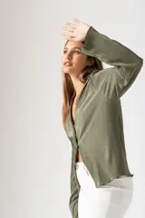 Camisa verde militar plisada con escote en V y tres botones.