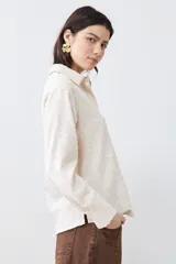 Camisa beige de manga larga con textura fantasía.