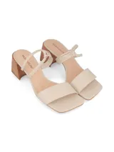 Sandalia de cuero sintético color negro, con taco cuadrado y punta cuadrada. Presenta una tira ancha sobre los dedos y dos tiras finas trenzadas sobre el empeine.