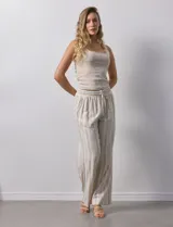 Pantalón de lino a rayas verticales color beige y blanco, con pretina ancha elastizada, lazo de ajuste y bolsillos inclinados.