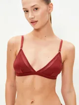 Conjunto de ropa interior negro, compuesto por un bralette triangular de tul y una tanga de tul con elástico fino.