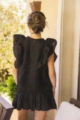 Minifalda negra de lino con detalle fruncido en todo el cuerpo y ruedo con volado amplio. Tiene cintura elástica.