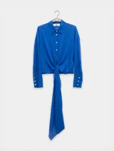 Camisa negra de manga larga con lazo en la cintura y botones nacarados. Confeccionada en 100% algodón y detalle de Polonio en cobre.