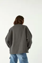 Buzo gris oscuro de algodón y poliéster con calce amplio y estampa frontal en color rosa con relieve.