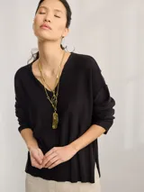 Buzo negro de tejido de punto con escote en V y mangas largas.