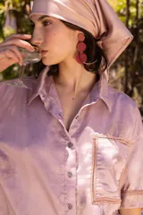 Camisa oversized de manga corta confeccionada en algodón con estampa de limones. Presenta un diseño de calce amplio y largo cropped, con cuello clásico y un bolsillo frontal con detalle de costura decorativa.