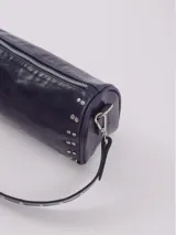 Bandolera color rojo de cuero con tachas plateadas. Tiene dos asas desmontables, una corta con tachas para llevarla en la mano o al hombro y una larga para llevarla al hombro o cruzada. Tiene bolsillo interior con cierre y forro.