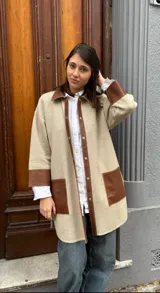 Camisa color beige con detalles en cuero marrón en cuello, solapa, bolsillos y puños.