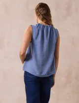Blusa celeste sin mangas en crepe con cuello a la base con frunce, apertura ojal y botón.