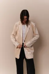 Blazer negro con detalles de lentejuelas, de corte holgado y solapas amplias.