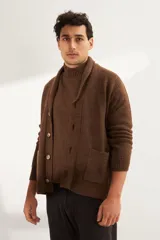 Cardigan tejido color marrón con cuello smoking, cierre con botones y bolsillos delanteros.