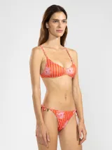 Top de bikini color naranja con estampado de rayas verticales blancas y flores rosas.